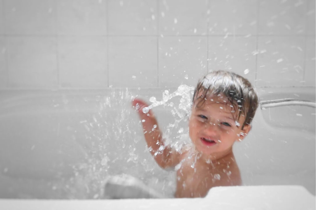 Baby having simple fun splashing in the bath